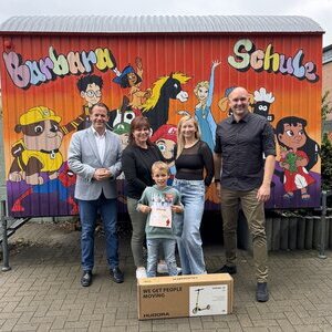 Bürgermeister Frank Keppeler bei der Gewinnübergabe an der Barbaraschule