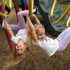 Zwei Mädchen im Kindergartenalter auf einem Klettergerüst