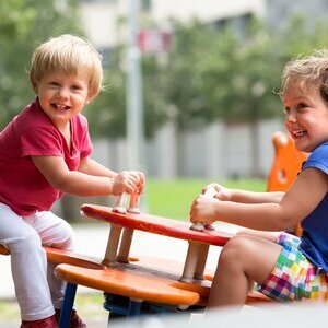 Kinder wippen auf dem Spielplatz